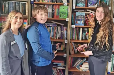  ?? ?? ●●The Co-operative’s Lindsey Milnes is shown round the Keystage 2 library by two of Holy Trinity’s school librarians.