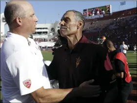  ??  ?? Arizona State head coach Herm Edwards (right) shakes hands with Southern California head coach Clay Helton after Arizona State’s 38-35 win during an NCAA college football game on Saturday, in Los Angeles. AP PHOTO/MARCIO JOSE SANCHEZ