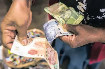  ?? PHOTO: BLOOMBERG ?? A vendor counts out rand banknotes while working in an African craft market in Rosebank, Johannesbu­rg. The writer remembers his early experience of an official and a black-market exchange rate in Ghana, which differed vastly.