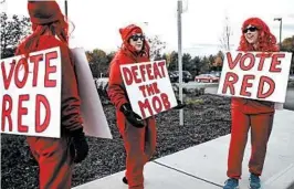  ?? CHERYL SENTER/AP ?? Republican­s signal their support — “Vote Red” and “Defeat the Mob” — this week in Bedford, N.H. Below, a Pittsburgh neighborho­od shows which way it may be leaning Tuesday.