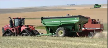  ?? Photo by Matthew Liebenberg ?? A combine unloads into a grain cart during the harvesting of a canola crop at the Lone Tree community project near Swift Current, Aug. 23. See more on Page 15.