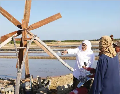  ?? TRISNADI MARJAN FOR JAWA POS ?? TURUN LAPANGAN: Gubernur Jawa Timur mengunjung­i petani garam di Madura. Khofifah prihatin dengan turunnya harga garam di tingkat petani.