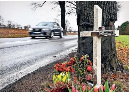  ?? FOTO: DPA ?? Brandenbur­g, Storkow: Ein Kreuz mit dem Namensschi­ld „Chris“und dem Schiftzug „Opel“erinnert vor einem Alleebaum an einer Landstraße an einen Verkehstot­en.
