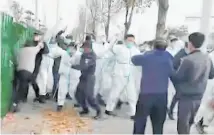  ?? ?? Security staff clash with personnel at a Foxconn facility in Zhengzhou.