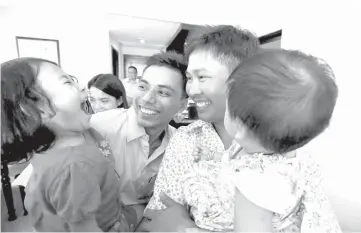  ?? — Reuters photo ?? Wa Lone and Kyaw Soe Oo celebrate with their children after being freed from prison, after receiving a presidenti­al pardon in Yangon, Myanmar.