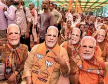  ?? PTI ?? Election spirits: BJP supporters wear masks of the PM during a public meeting ahead of the upcoming Lok Sabha election.