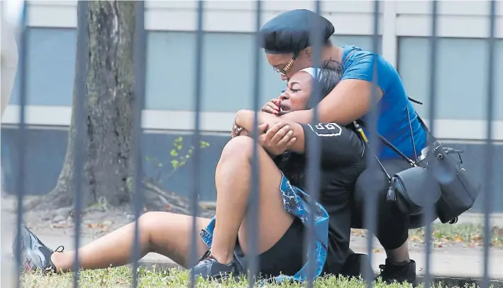  ?? AP ?? Dolor. Dos mujeres lloran en las afueras del Stroger Hospital, en Chicago, luego de un tiroteo en el que murieron varias personas en la ciudad, una de las más violentas de EE.UU.