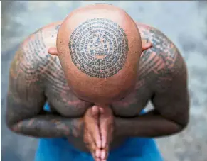  ?? — Reuters ?? Saying his prayers: A devotee attends the religious tattoo festival at Wat Bang Phra Monastery, where devotees believe that their tattoos have mystical powers, in Nakhon Pathom province, Thailand.