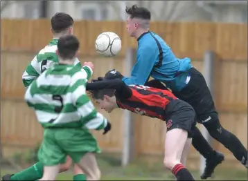  ??  ?? Conor Conway, Bellurgan feels the pressure of this challenge from Trim Celtic’s ‘keeper Glenn Prendergas­t.