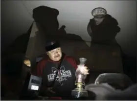  ?? JAKE BACON — THE ASSOCIATED PRESS ?? Jimmie Long Jr. places the glass on an oil lamp inside his Kaibeto home on the Navajo Reservatio­n in Arizona earlier this month.