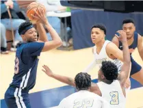  ?? KYLE TELECHAN / POST-TRIBUNE ?? West Side’s Jalen Washington, left, looks to pass under pressure by the Elkhart defense during the Class 4A Michigan City Regional semifinals on Saturday.