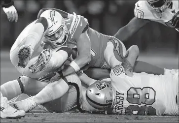  ?? D. Ross Cameron Associated Press ?? PHILIP RIVERS, top, is sacked by Oakland Raiders defensive end Maxx Crosby, bottom right, and other Raiders during the first half. Oakland sacked Rivers five times and hit him another five times.