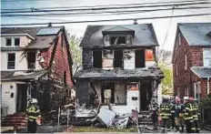  ?? AP ?? New York Fire Department personnel stand outside the scene of a deadly fire on Sunday in Queens Village, New York. There was no immediate theory on what started the blaze.