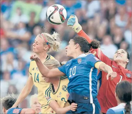  ?? Jewel Samad
AFP/Getty Images ?? U.S. GOALKEEPER HOPE SOLO reaches in to punch the ball away as Sweden’s Amanda Ilestedt (14) goes for a header and Carli Lloyd (10) does her best to help out Solo at Winnipeg. The Americans still lead Group D with one game to play.