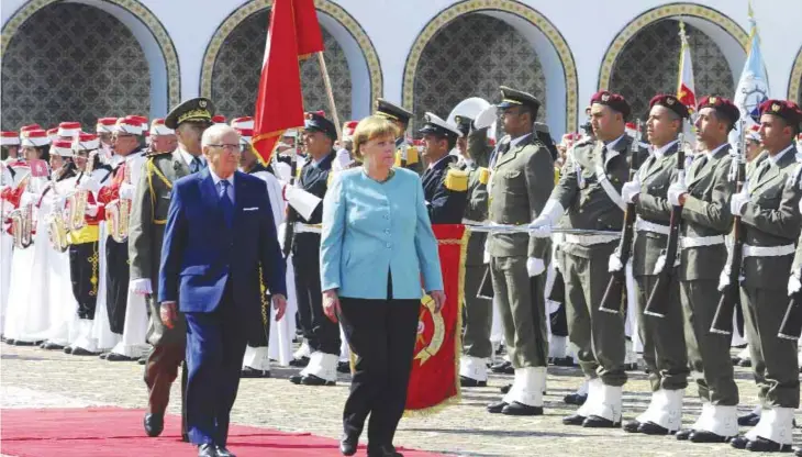  ??  ?? TUNIS: Tunisian President Beji Caid Essebsi, left, walks with German Chancellor Angela Merkel, while reviewing an honor guard during an official welcome ceremony at the presidenti­al palace in Carthage, near Tunis, Tunisia, yesterday. —AP