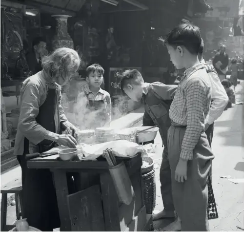  ??  ?? Something smells good A street food hawker in 1950s Hong Kong (above); Mong Kok is still a hotspot for fans of local street food (right)