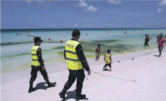  ?? AFP ?? Police officers patrol the beach on Boracay, part of a 600-strong contingent on duty as tourism businesses on the island face up to the loss of their customers