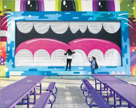  ?? Photograph­s by Marcus Yam Los Angeles Times ?? VISITORS get an intimate view of a Greg Mike whimsical mural at Robert F. Kennedy Community Schools in Koreatown.