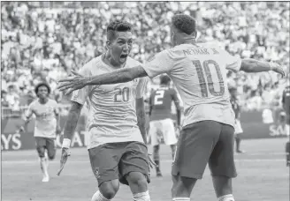  ?? AP PHOTO ?? Brazil’s Roberto Firmino, left, celebrates with Brazil’s Neymar, right, after scoring his side’s second goal during the round of 16 match between Brazil and Mexico at the 2018 soccer World Cup in the Samara Arena, in Samara, Russia, Monday.