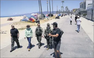  ?? MARCIO JOSE SANCHEZ — THE ASSOCIATED PRESS ?? Members of the Los Angeles County Sheriff’s Department’s HOST, Homeless Outreach Service Team, walk past tents set up by unhoused people Tuesday in the Venice Beach section of Los Angeles.