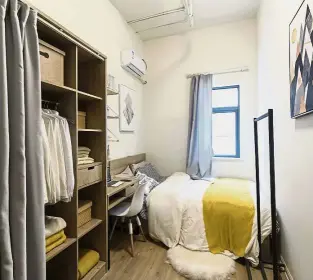  ??  ?? A bedroom inside a unit at the same apartment project at China Vanke Co’s Port Apartment project in Shanghai. (Right) Employees tidying up a communal recreation room at the facility. — Bloomberg