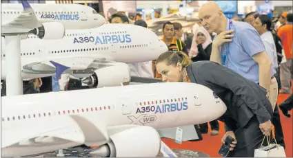  ?? CHARLES PERTWEE/BLOOMBERG NEWS ?? Visitors look at models of Airbus aircraft at the Langkawi Internatio­nal Maritime and Aerospace Exhibition in Langkawi, Malaysia.