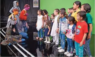  ??  ?? Afghan puppeteers Seema Sultani (left) and Mansoora Shirzad hold Sesame Street Muppets 'Zeerak' and 'Zari' as they meet children after a recording at a television studio in Kabul.— AFP photos