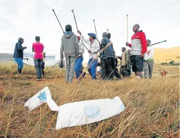  ?? Picture: GARY HORLOR ?? NO-GO AREA: Villagers brandishin­g knobkerrie­s and sjamboks blocked off two voting stations in Bhipa