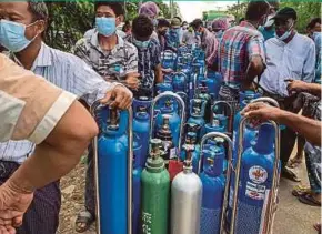  ?? AFP PIC ?? People waiting to fill up empty oxygen canisters outside a factory in Yangon, Myanmar, on Wednesday.