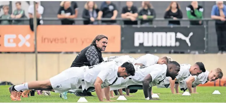  ?? FOTO: FEDERICO GAMBARINI/DPA ?? Im Liegestütz: Mönchengla­dbachs neuer Trainer Daniel Farke (M.) beobachtet das erste Training seiner Mannschaft.