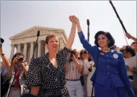  ?? ASSOCIATED PRESS FILE PHOTOS ?? In this April 26, 1989 file photo, Norma McCorvey, Jane Roe in the 1973 court case, left, and her attorney Gloria Allred hold hands as they leave the Supreme Court building in Washington after sitting in while the court listened to arguments in a...