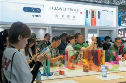  ?? CHINATOPIX VIA AP ?? Visitors look at a display of smartphone­s from Chinese technology firm Huawei at the Consumer Electronic­s Show in Shanghai, Tuesday. Chinese tech giant Huawei said Tuesday it would have become the world’s number one smartphone maker by year’s end if it were not for “unexpected” circumstan­ces — a hint that pressure from the U.S. may be hurting its sales.