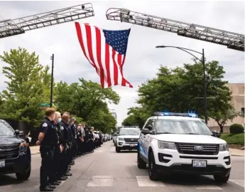  ?? ASHLEE REZIN/SUN-TIMES ?? Officers salute as an ambulance passes by carrying the body of a Chicago police officer who was found dead in an apparent suicide at the Homan Square facility in July 2020.