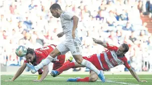  ??  ?? Real Madrid’s Eden Hazard, centre, scores against Granada.