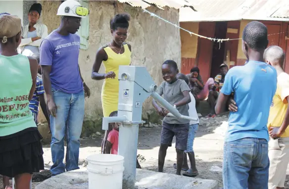  ??  ?? Built with the support of Lifewater Canada, community members celebrate a new well in Haiti — bringing fresh, clean water to their area.
