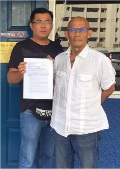  ??  ?? Peter John (right) and his deputy Mohammad Iryani Yaman at the Jalan Simpang Tiga Kuching police station showing the police permit.