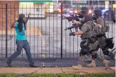  ?? WHITNEY CURTIS FOR THE NEW YORK TIMES ?? Police officers in riot gear confront a man Aug. 11, 2014, during a protest in Ferguson, Mo., over the shooting of a black teenager, Michael Brown.