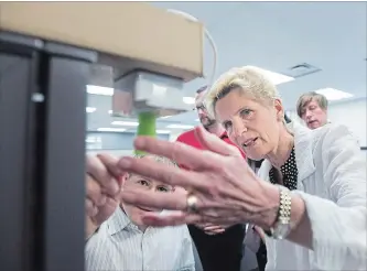  ?? NATHAN DENETTE THE CANADIAN PRESS ?? Liberal Premier Kathleen Wynne, who has ordered a Hydro One compensati­on review, takes a look at a sensor at eleven-x, an internet of things company in Waterloo, on Tuesday during a campaign stop.