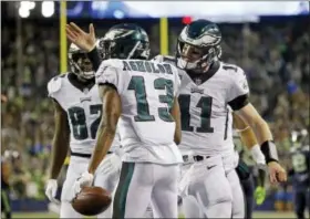  ?? TED S. WAREN — THE ASSOCIATED PRESS ?? Philadelph­ia Eagles quarterbac­k Carson Wentz (11) congratula­tes Nelson Agholor (13) on his touchdown reception against the Seattle Seahawks during the second half of last week’s game in Seattle. Agholor will have a homecoming of sorts on Sunday when...