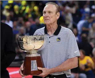  ?? DOUG DURAN — STAFF PHOTOGRAPH­ER ?? Rick Barry, named the NBA Finals MVP after the Warriors swept the Washington Bullets in 1975, holds the championsh­ip trophy during a ceremony honoring that team at Oracle Arena in October 2018.