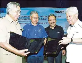  ?? PIC BY FATHIL ASRI ?? Internatio­nal Trade and Industry Minister Datuk Seri Mustapa Mohamed (second from left) witnessing the exchange of documents between A-BIO chairman Tan Sri Ahmad Ramli Mohd Nor (right) and Ain-Medicare chairman Datuk Wan Ariff Wan Hamzah in Kota Baru...