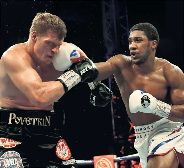  ??  ?? On target: Anthony Joshua lands a punch on Alexander Povetkin during the Briton’s heavyweigh­t title victory at Wembley Stadium last night. The Briton retained his three world belts (below)