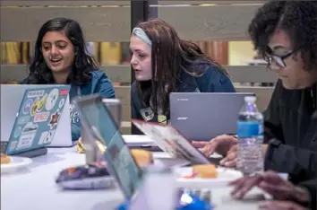  ?? Alexandra Wimley/Post-Gazette ?? From left, Eshani Chauk of Sewickley, Skye Bondra of Export and Alyza Foster of Wilkins work on a project during Thursday's GirlGov meeting at Nova Place.