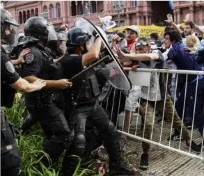  ?? AFP ?? Los aficionado­s saltaron las barreras con tal de no quedarse sin entrar a la sala de velación en la Casa Rosada.