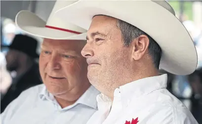  ?? JEFF MCINTOSH THE CANADIAN PRESS FILE PHOTO ?? Premiers Doug Ford and Jason Kenney attend the Calgary Stampede last July. At first, their policy playbooks had much in common.