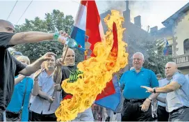  ??  ?? Vojislav Šešelj (Zweiter v. re.) bei der Verbrennun­g einer kroatische­n Flagge 2015. Dass er in Serbien frei herumläuft, stört Zagreb.