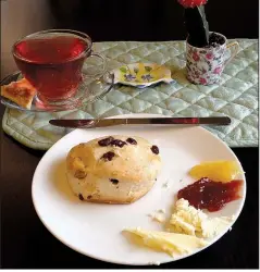  ??  ?? Arkansas Democrat-Gazette/JENNIFER NIXON A cup of fruity Blueberry Lemongrass tea and a cranberry pecan scone with all the spreads is perfect for a rainy afternoon snack at Abbi’s Teas &amp; Things.