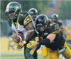  ??  ?? AARON LYNETT/ THE CANADIAN PRESS Eskimos running back Hugh Charles is tackled by Ticats defensive back Erik Harris at Guelph, Ont., on Sunday.