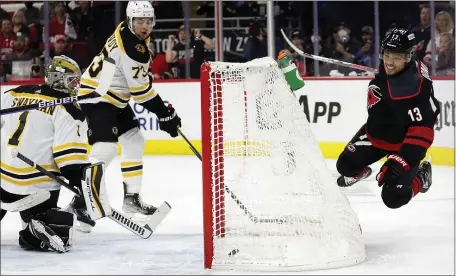  ?? AP ?? END OF THE ROAD: Carolina’s Max Domi dives over the net after getting the puck past Charlie McAvoy and goaltender Jeremy Swayman for a goal during the second period of the Bruins’ 3-2 loss in Saturday’s Game 7.