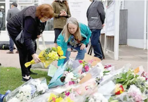  ?? Agence France-presse ?? Well-wishers place floral tributes at the scene of the fatal stabbing of David Amess, at Belfairs Methodist Church in Leigh-on-sea, a district of Southend-onSea, in southeast England on Saturday.